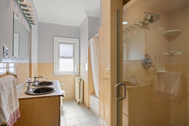 full bath with wainscoting, radiator, tile patterned floors, curtained shower, and tile walls