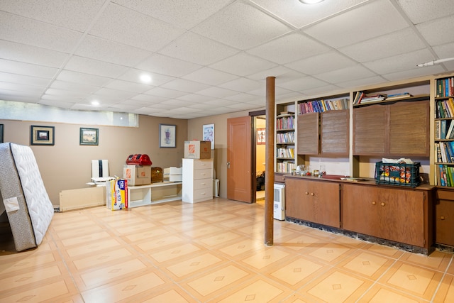 finished basement featuring light floors and a drop ceiling