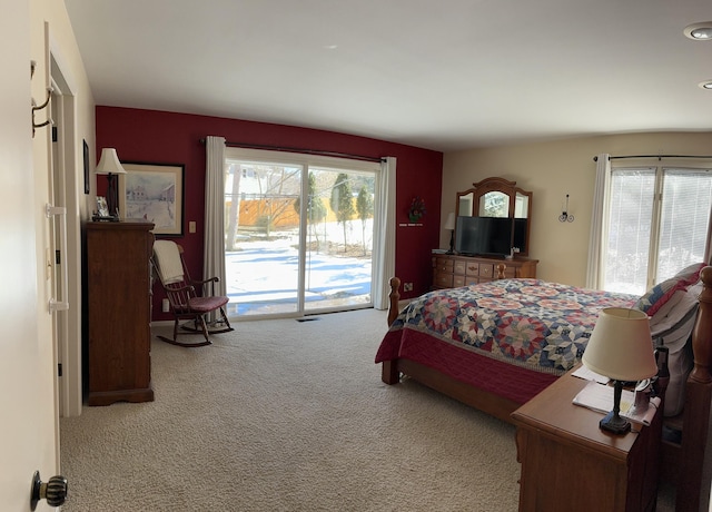 bedroom with carpet floors, access to outside, and multiple windows