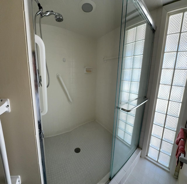 bathroom with a shower stall and tile patterned floors