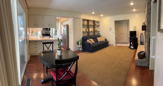 living area with visible vents, wood finished floors, and recessed lighting