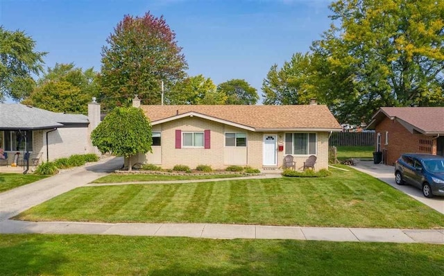 ranch-style house featuring a front lawn, fence, brick siding, and a chimney