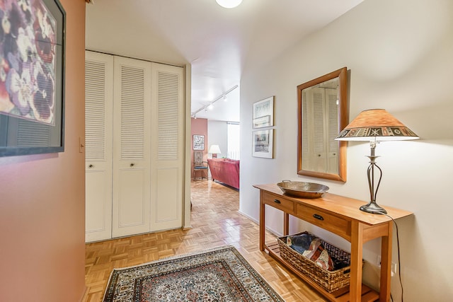 corridor featuring baseboards and track lighting