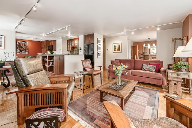 living room featuring rail lighting and an inviting chandelier