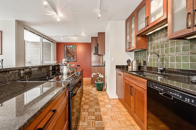 kitchen with brown cabinets, backsplash, a sink, dark stone counters, and black appliances