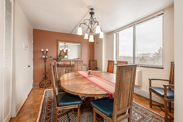 dining space featuring baseboards and an inviting chandelier