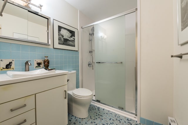 full bathroom with toilet, tile patterned flooring, vanity, a shower stall, and tile walls