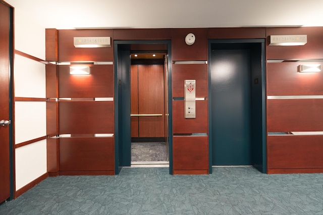 interior space featuring elevator and carpet flooring