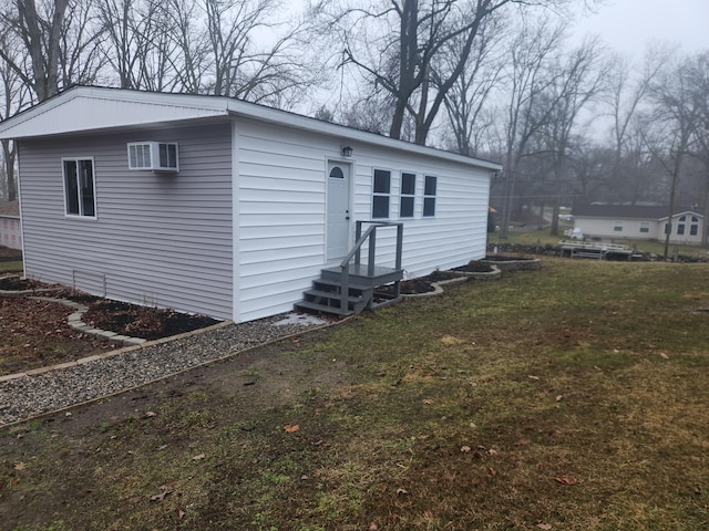 view of front of property with an AC wall unit and a front yard