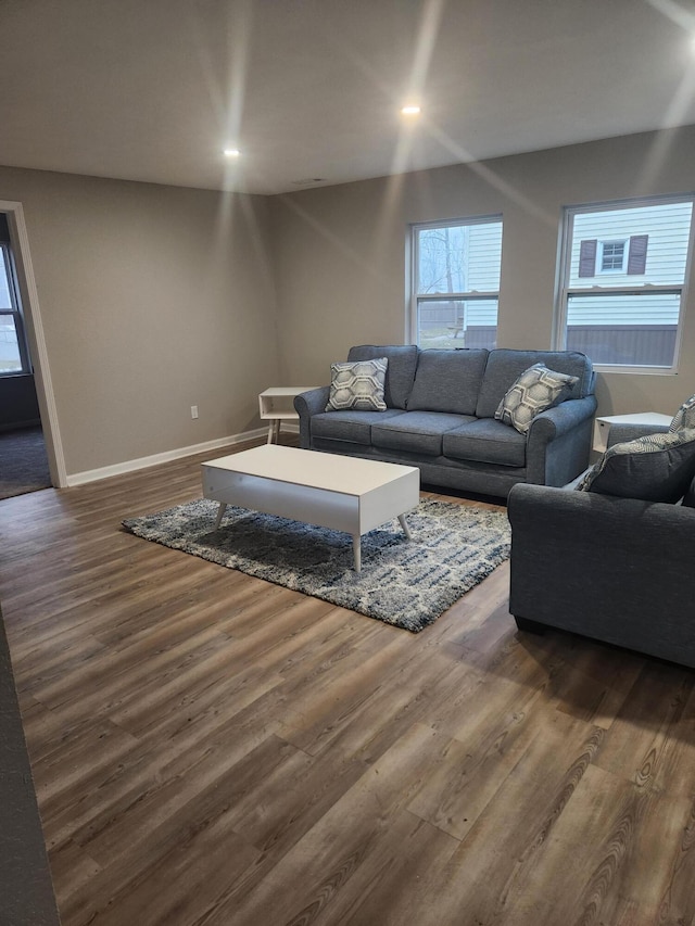 living area with recessed lighting, dark wood-style flooring, and baseboards