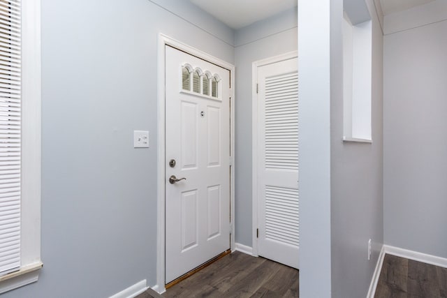 doorway to outside featuring dark wood-type flooring and baseboards