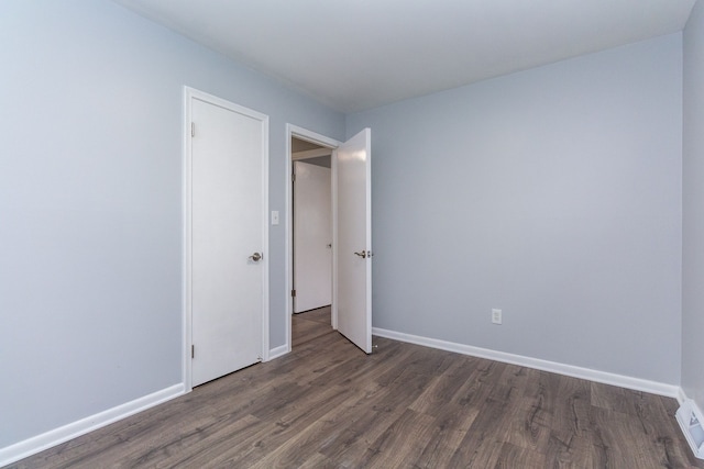 unfurnished bedroom featuring baseboards and wood finished floors