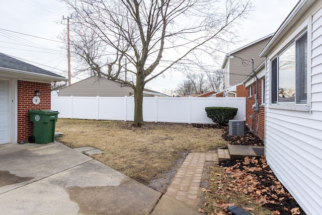 view of yard with central AC and a fenced backyard