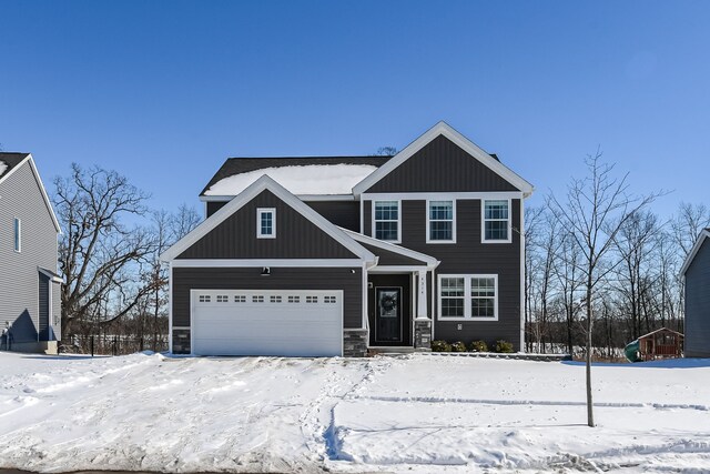 view of front of property featuring an attached garage, board and batten siding, and stone siding