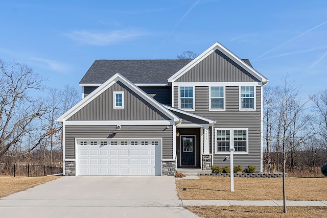 view of front of property with a garage, stone siding, board and batten siding, and concrete driveway