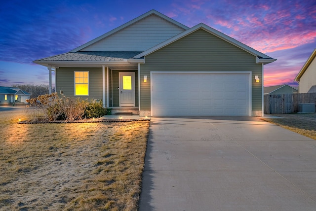 view of front of house with concrete driveway, an attached garage, fence, and cooling unit