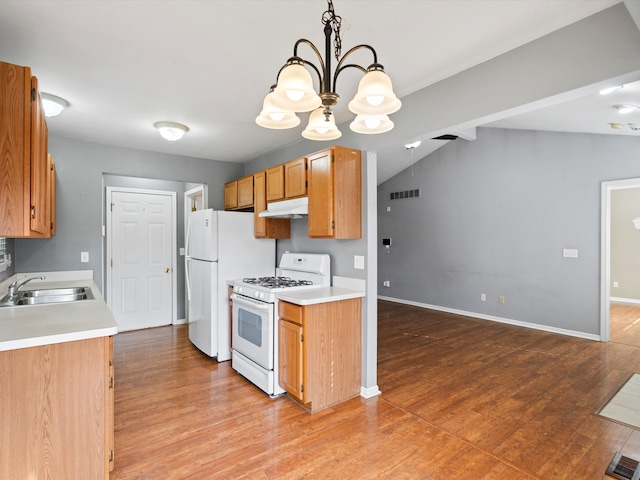 kitchen featuring light wood finished floors, visible vents, a sink, white appliances, and under cabinet range hood