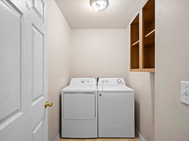 clothes washing area with laundry area, baseboards, and independent washer and dryer