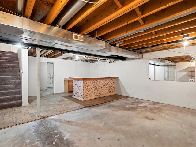 unfinished basement featuring stairs and visible vents