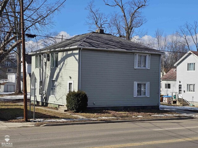 view of side of property with entry steps and a chimney