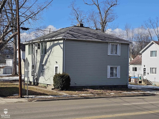 view of property exterior with a chimney and entry steps