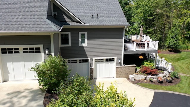 view of property exterior with a garage, concrete driveway, roof with shingles, and stairs