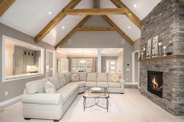 living area featuring high vaulted ceiling, a fireplace, decorative columns, and beam ceiling