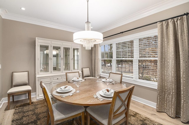 dining area featuring baseboards, an inviting chandelier, wood finished floors, and crown molding