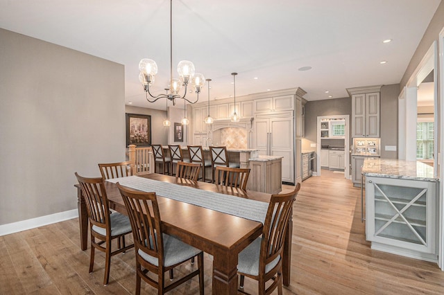 dining room with light wood finished floors, baseboards, a notable chandelier, and recessed lighting