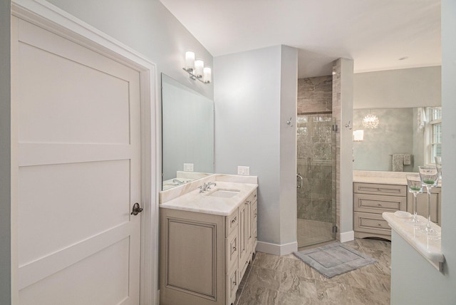 full bath with marble finish floor, a stall shower, vanity, and baseboards