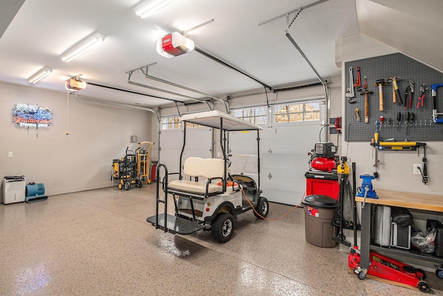 garage with a workshop area and a garage door opener