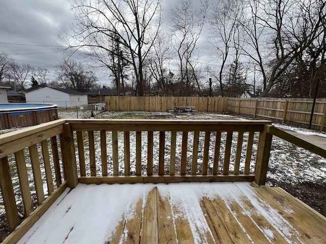 snow covered deck featuring a fenced backyard