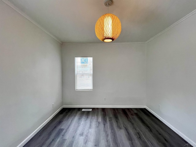 empty room featuring ornamental molding, visible vents, dark wood finished floors, and baseboards