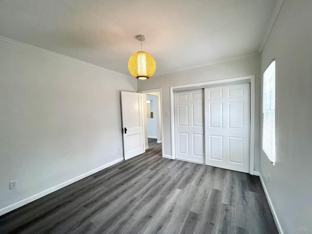 unfurnished bedroom featuring dark wood-style floors, multiple windows, and baseboards