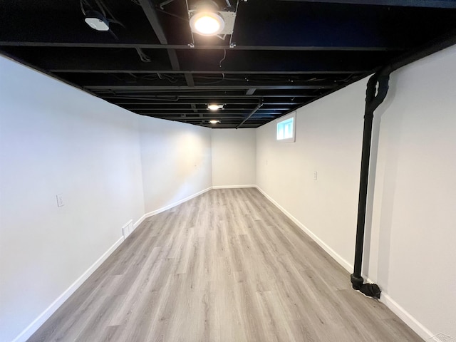 below grade area featuring baseboards and wood finished floors