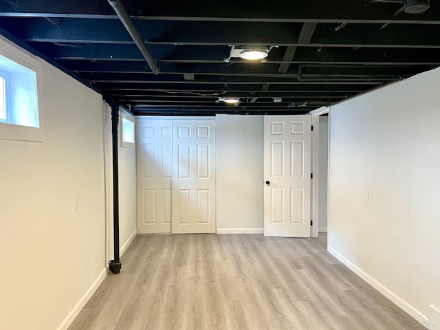 below grade area featuring baseboards and light wood-style floors