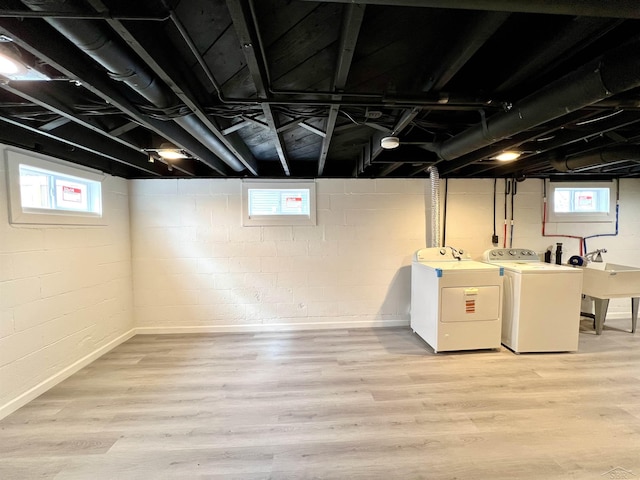 basement featuring light wood-type flooring and washing machine and dryer