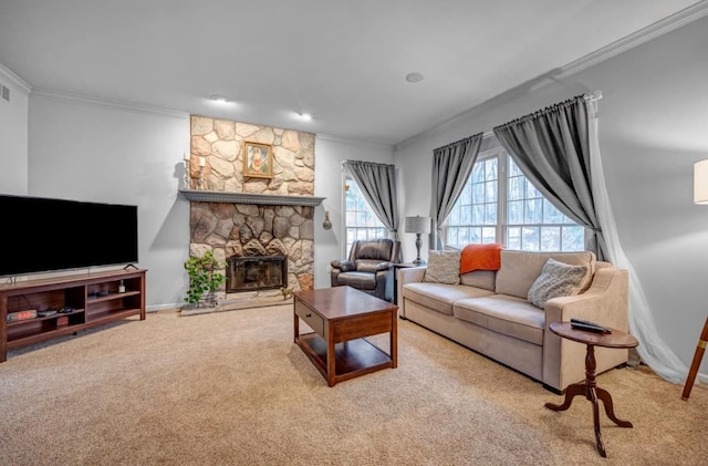 living area with visible vents, baseboards, ornamental molding, carpet flooring, and a stone fireplace