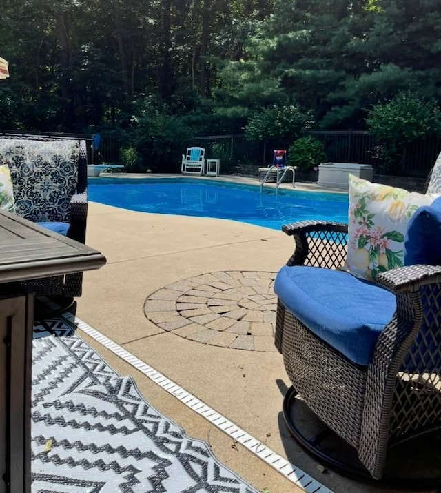 view of swimming pool featuring a patio, fence, and a fenced in pool