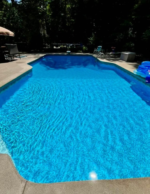 pool featuring a diving board and a patio