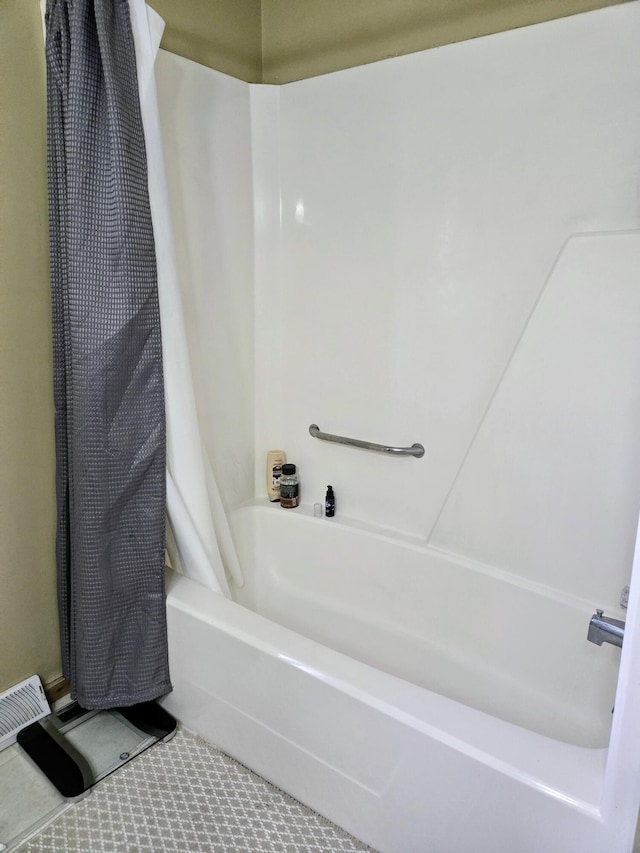 full bath featuring tile patterned flooring and shower / tub combo with curtain