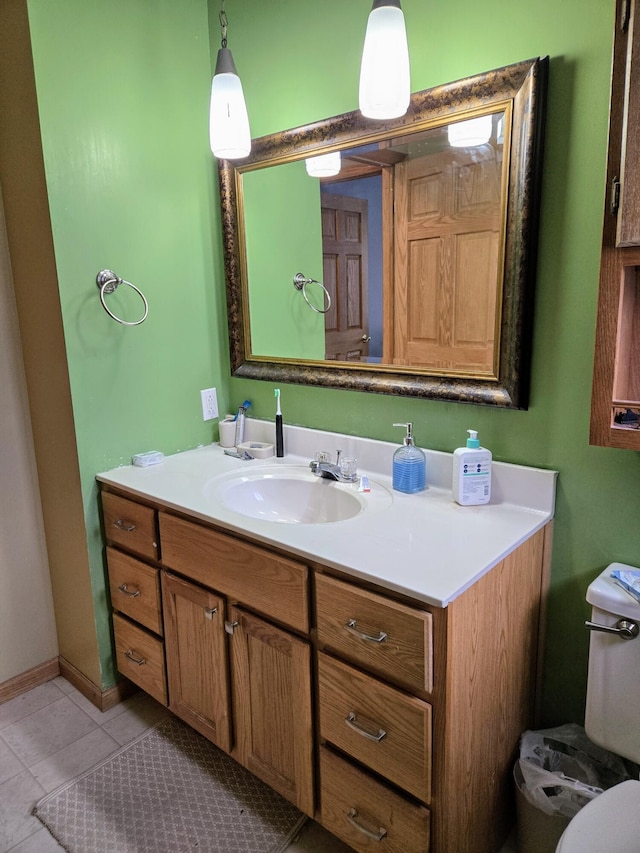 bathroom featuring baseboards, vanity, toilet, and tile patterned floors