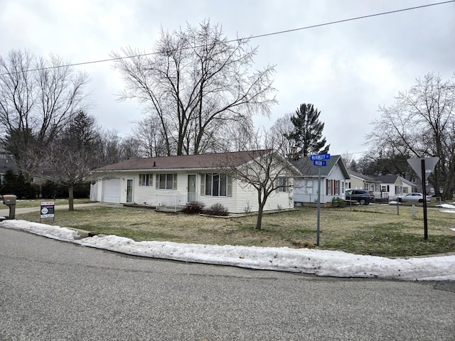 view of front of house featuring a front lawn, driveway, and an attached garage