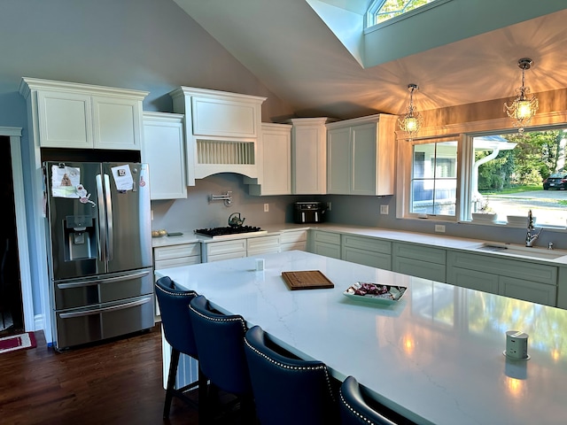 kitchen featuring white cabinets, stainless steel fridge with ice dispenser, vaulted ceiling, a sink, and black gas stovetop