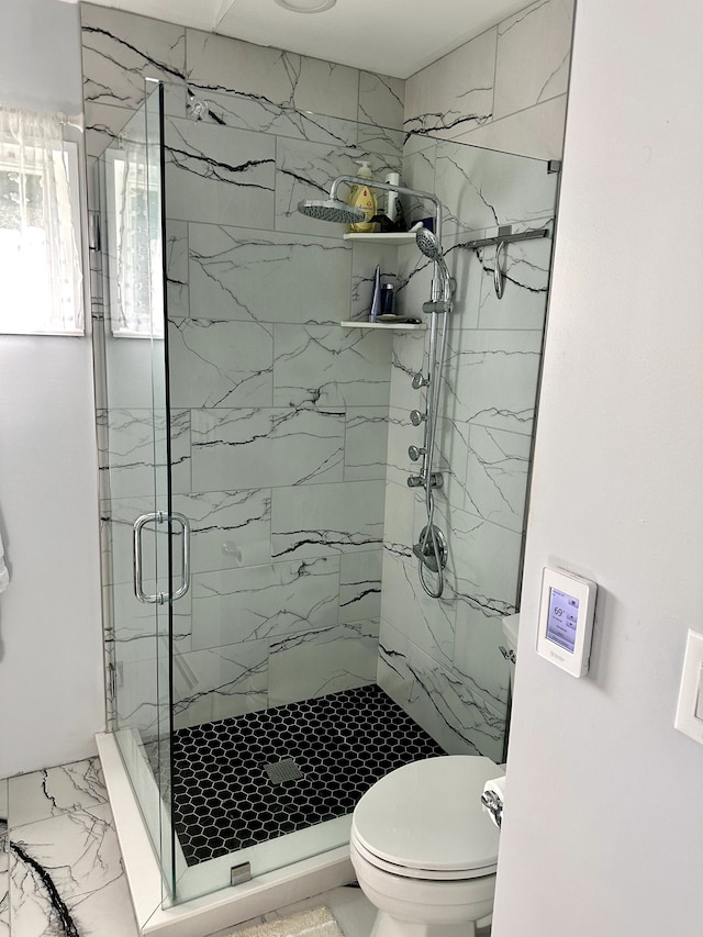 bathroom with marble finish floor, toilet, and a marble finish shower