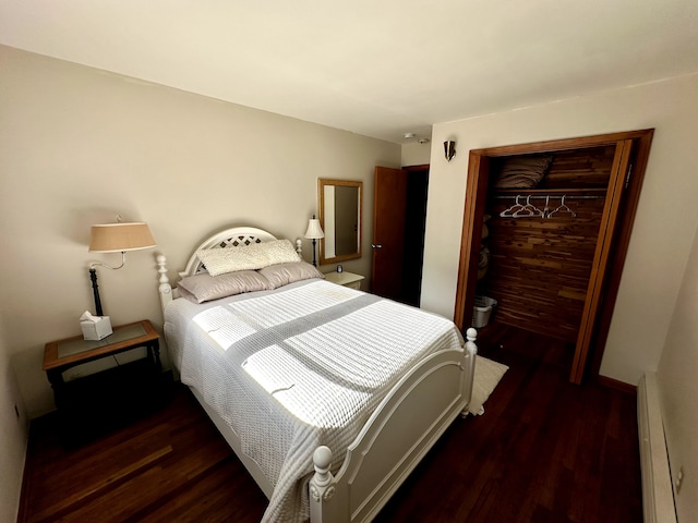 bedroom with baseboard heating, a closet, and wood finished floors