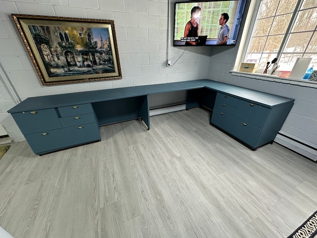 office area with concrete block wall and light wood-style flooring