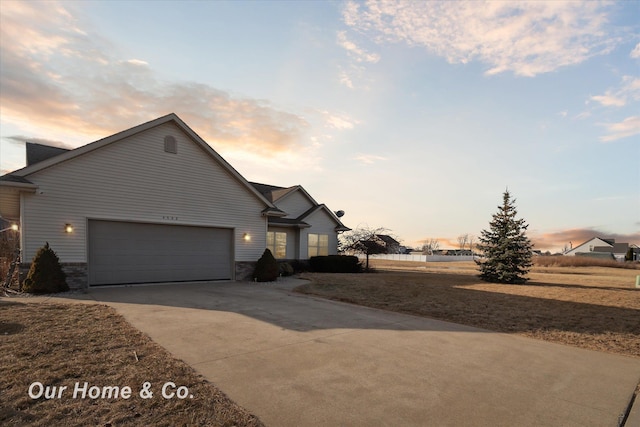 view of front of house featuring a garage, stone siding, and concrete driveway