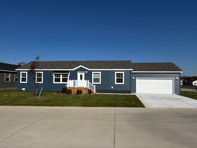 view of front of home featuring a front yard, concrete driveway, and an attached garage