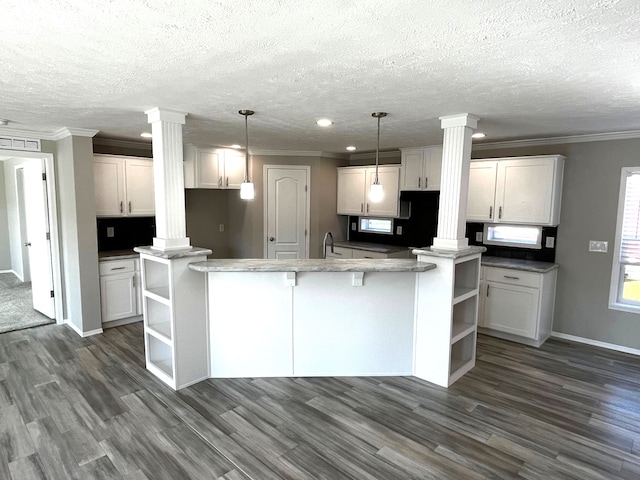 kitchen with white cabinetry, open shelves, dark wood-style floors, and ornate columns